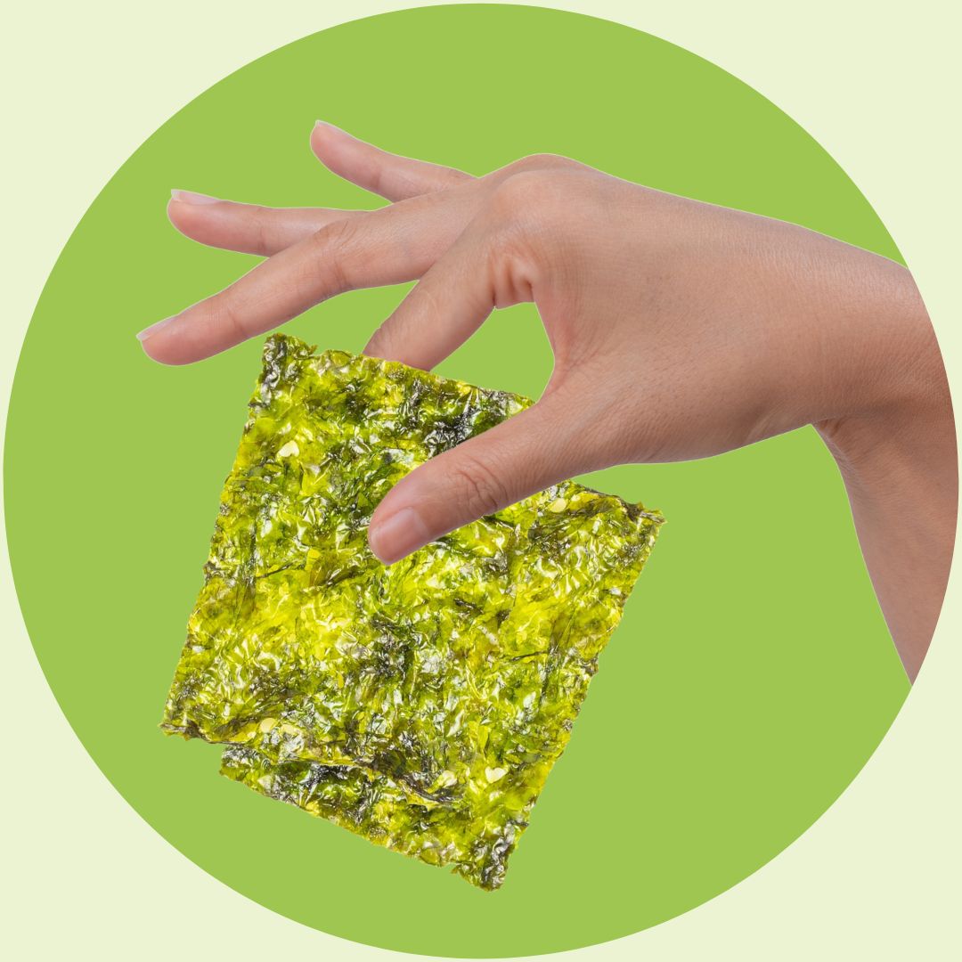 Superfood snack held by hand on green background | Morish Snacks