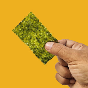 Hand holding crispy sesame oil seaweed between fingers| Morish Snacks
