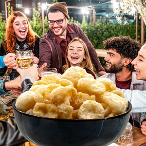 Bowl of pork chicharrónes sea salt with people laughing | Morish Snacks